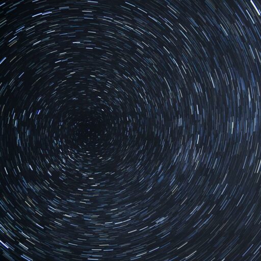 Dazzling star trails creating a spiral effect in the clear night sky.