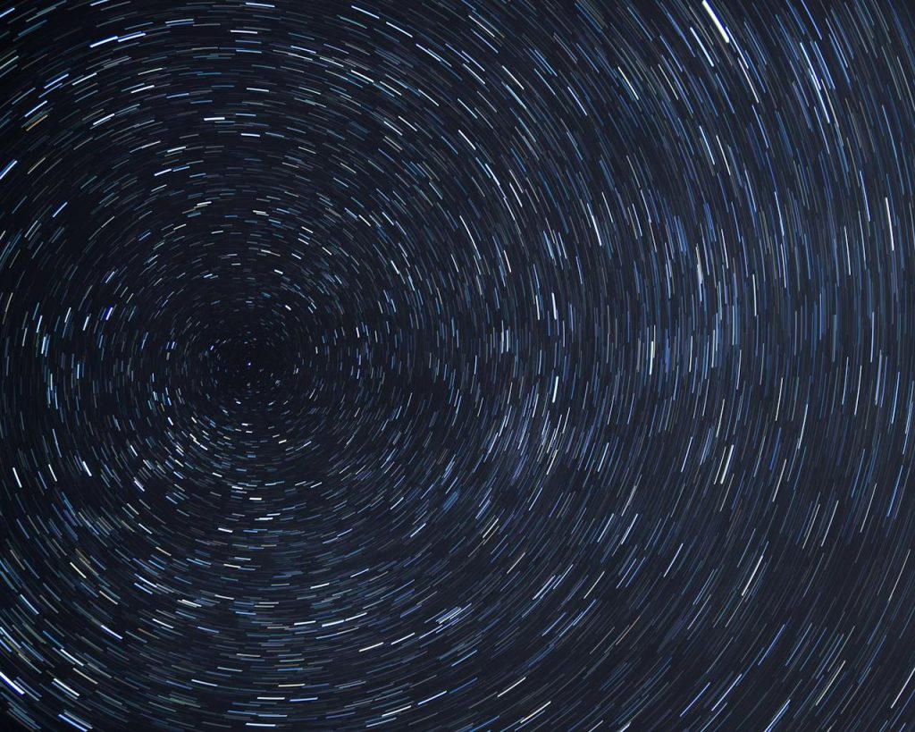 Dazzling star trails creating a spiral effect in the clear night sky.